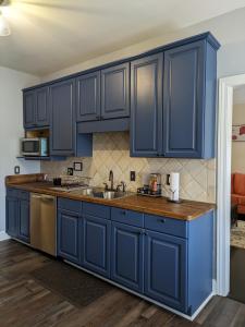a kitchen with blue cabinets and a wooden floor at The Elizabeth in Columbia