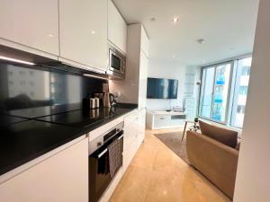 une cuisine avec des comptoirs noirs et un canapé dans l'établissement Luxury 1 Bed - City Suites Ocean Spa Plaza, à Gibraltar