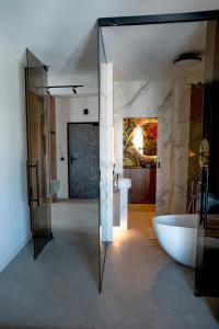 a bathroom with a bath tub and a glass wall at Fetch the Sky in Kraków