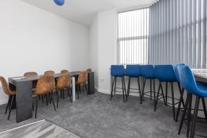 a conference room with a table and blue stools at 54 Central in Blackpool