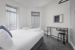 a bedroom with a large white bed and a desk at 54 Central in Blackpool