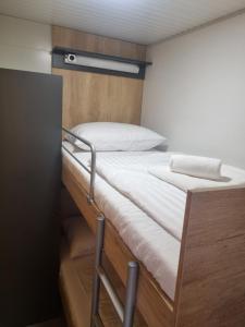 ein Etagenbett in einem kleinen Zimmer mit einer Leiter dazu in der Unterkunft Hipo camp - Mobil home Sestrica in Pakoštane