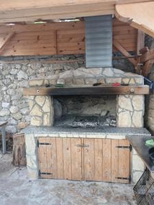 an outdoor kitchen with a stone wall and a stove at Hipo camp - Mobil home Sestrica in Pakoštane
