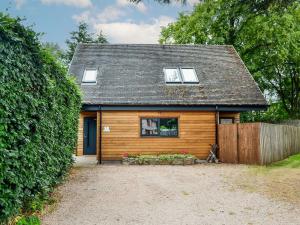 uma pequena casa de madeira com uma janela e uma cerca em Cedar Cottage em Aboyne