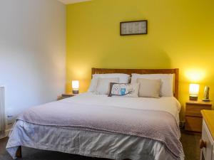 um quarto com uma cama grande e uma parede amarela em Cedar Cottage em Aboyne