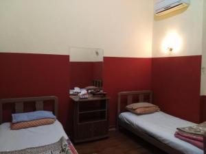 2 camas en una habitación con paredes rojas y blancas en Safary Hotel, en El Cairo