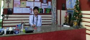 un hombre está sonriendo detrás de un mostrador en una tienda en Safary Hotel, en El Cairo