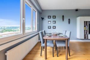 comedor con mesa, sillas y ventana en Spacious flat in Ecully with views of Lyon, en Écully