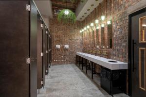 a bathroom with a row of sinks and mirrors at Sandman Signature Glasgow Hotel in Glasgow