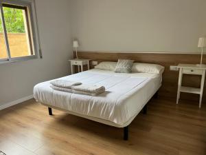 a bedroom with a large bed with two towels on it at Apartaments La Pertusa in Corçà