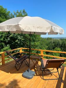 a table and two chairs under an umbrella on a deck at Forest paradise in Koprivnica