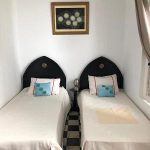 two beds sitting next to each other in a room at Dar Nakhla Naciria in Tangier