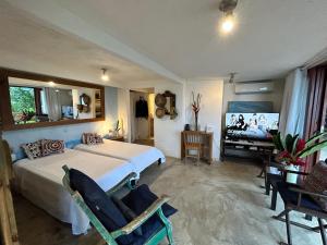a bedroom with a bed and a flat screen tv at Suíte e sala - Vista Barra do Sahy in São Sebastião
