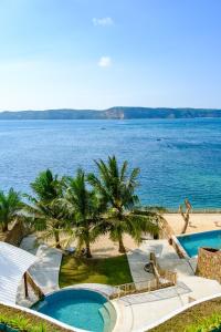 einen Blick auf das Meer von einem Resort mit 2 Pools in der Unterkunft Inlight Lombok Beach Hotel in Kuta Lombok