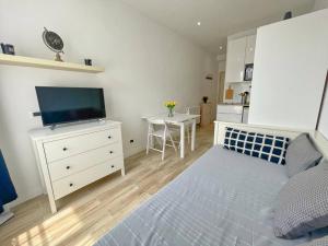 een slaapkamer met een bed en een dressoir met een televisie bij Studio au coeur de Nice in Nice