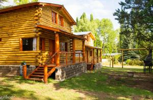 Cabaña de madera con porche y escaleras. en Rincón Lejano en Potrerillos