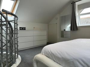 1 dormitorio con 1 cama y vestidor blanco en Seaside Home, en Ardeer Square