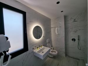 łazienka z umywalką, toaletą i oknem w obiekcie White Villa w mieście Përmet