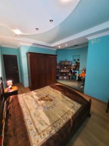 a large bed in a room with blue walls at Umbrella Kutaisi - Guest house in Kutaisi