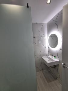 a bathroom with a sink and a mirror at White Villa in Përmet
