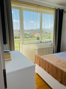 a bedroom with two beds and a large window at Bliss Râșnov in Râşnov