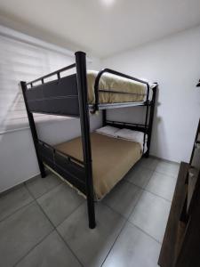 Ce lit superposé noir se trouve dans un dortoir. dans l'établissement Nuevo y amplio departamento con alberca y seguridad en el centro de Guadalajara, à Guadalajara 15 autres photos