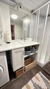 een badkamer met een wastafel en een wasmachine bij “ Mandala” place for 2 in Sauda