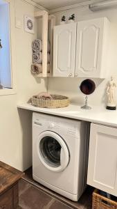 uma lavandaria com uma máquina de lavar roupa debaixo de um balcão em “ Mandala” place for 2 em Sauda
