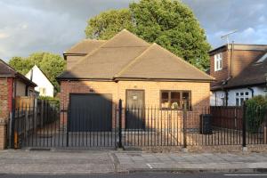 una casa de ladrillo con una puerta y una valla en OPULENT HOUSE London, en Dagenham