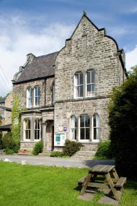 ein Steingebäude mit einem Picknicktisch davor in der Unterkunft YHA Hathersage in Hathersage