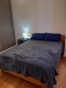 Un dormitorio con una cama con una manta azul. en Céntrico y Cómodo departamento VIP, en La Paz