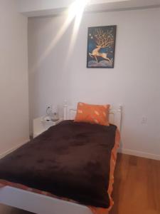 Una cama en una habitación blanca con una luz en la pared en Céntrico y Cómodo departamento VIP, en La Paz