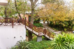 a wooden staircase in a park with trees and plants at O2 Hotel Valeria del Mar in Valeria del Mar