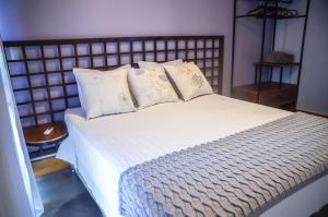 a bedroom with a large bed with white sheets and pillows at Vila Astra - jacuzzi privativa, natureza e conforto in Alto Paraíso de Goiás