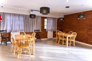 een eetkamer met houten tafels en stoelen bij O2 Hotel Valeria del Mar in Valeria del Mar