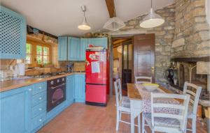 eine Küche mit blauen Schränken und einem roten Kühlschrank in der Unterkunft Amazing Home In Groznjan With House A Panoramic,,, in Grožnjan
