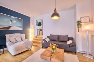 a living room with a couch and a chair at Stilvolle Stadtwohnungen Bremen I Komfort & Charme in Bremen