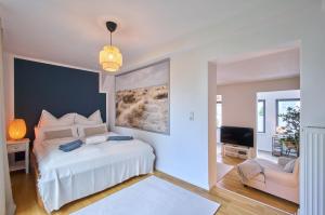1 dormitorio con 1 cama blanca y 1 silla en Charmante Altbremer Wohnung I Wintergarten I Küche I Balkon, en Bremen