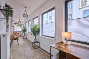 a room with windows and a desk with a lamp at Stilvolle Stadtwohnungen Bremen I Komfort & Charme in Bremen