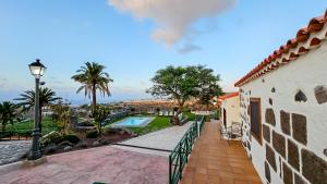 a balcony of a house with a pool and palm trees at Finca Los Ángeles in Trapiche