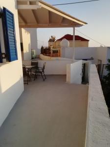 einen Balkon mit Stühlen und einem Tisch auf einem Gebäude in der Unterkunft Andros Breeze in Batsi