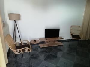 a living room with a television and a table and chairs at Andros Breeze in Batsi