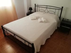 a bedroom with a bed with two towels on it at Andros Breeze in Batsi