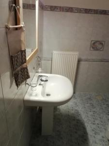 ein Badezimmer mit einem weißen Waschbecken und einem Spiegel in der Unterkunft Andros Breeze in Batsi