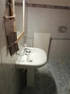 a bathroom with a white sink and a mirror at Andros Breeze in Batsi +6 photos