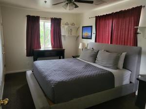 Tail Wind Life LLC في بيج: غرفة نوم بسرير كبير مع ستائر حمراء