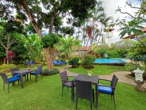 a garden with tables and chairs and a pool at Balinda Rooms & Villa in Lovina