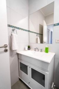 Baño blanco con lavabo y espejo en Casas Los Alamos - Alquiler temporario en Esquel