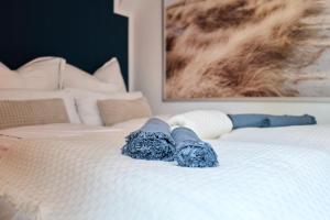 a white bed with blue socks on top of it at Stilvolle Stadtwohnungen Bremen I Komfort & Charme in Bremen