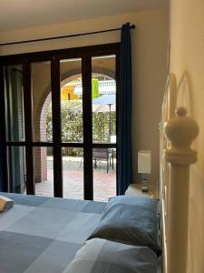 Schlafzimmer mit einem Bett und einer Tür zu einer Terrasse in der Unterkunft Casa Tea in Lucca